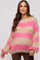 woman wearing a striped pink and beige oversized maternity sweater with a relaxed fit and visible baby bump