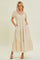 woman wearing a white maxi dress with yellow floral pattern and puff sleeves, featuring side pockets