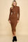woman wearing a brown ribbed long sleeve midi dress with side buttons and a long pendant necklace