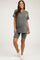 woman wearing a grey ribbed maternity top and matching shorts, showcasing a baby bump