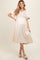 woman wearing a cream maternity dress with floral embroidery and short sleeves, baby bump visible