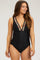 woman wearing a black maternity swimsuit with colorful embroidered details and a deep V-neckline