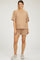 woman wearing a beige maternity wear short sleeve waffle knit top and matching shorts, with a relaxed fit and no visible baby bump