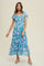 woman wearing a blue floral midi dress with short sleeves and a smocked bodice