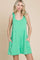 woman wearing a green sleeveless dress with side pockets and tie straps