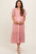 woman wearing a pastel pink maternity dress with flutter sleeves and tiered tulle fabric, holding her baby bump