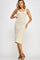 woman wearing a ribbed beige midi dress with a scoop neckline and side slit, standing with one hand on her hip