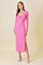woman wearing a pink long sleeve midi dress with a twist front detail and a thigh-high slit