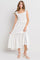 woman wearing a white smocked maxi dress with ruffled straps and a flowy hemline