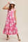 woman wearing a pink floral midi dress with tiered hem, accessorized with a white bucket hat and sandals