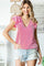 woman wearing a pink and white striped top with ruffle sleeves and distressed denim shorts
