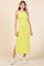 woman wearing a bright yellow sleeveless maxi dress with a side slit and white sneakers