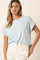 woman wearing a light blue oversized t-shirt with rolled sleeves and white distressed jeans