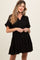 woman wearing a black tiered maternity dress with a v-neck and short sleeves, showing her baby bump