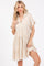 woman wearing a light beige short sleeve tiered dress with a collar and frayed hem