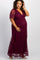 woman wearing a burgundy lace maternity dress with short sleeves and a deep v-neck, holding her baby bump