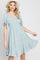 woman wearing a light blue floral print mini dress with flutter sleeves and a straw hat