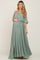 Pregnant woman wearing a sage green off-the-shoulder maternity maxi dress with a ruffled bodice and front slit