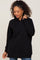 woman with curly hair wearing a black pullover hoodie with a front pocket and drawstrings