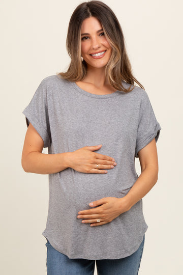 woman wearing a gray short sleeve maternity top and holding her baby bump