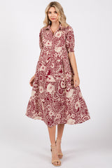 woman wearing a burgundy and cream floral midi dress with a collared neckline and puff sleeves