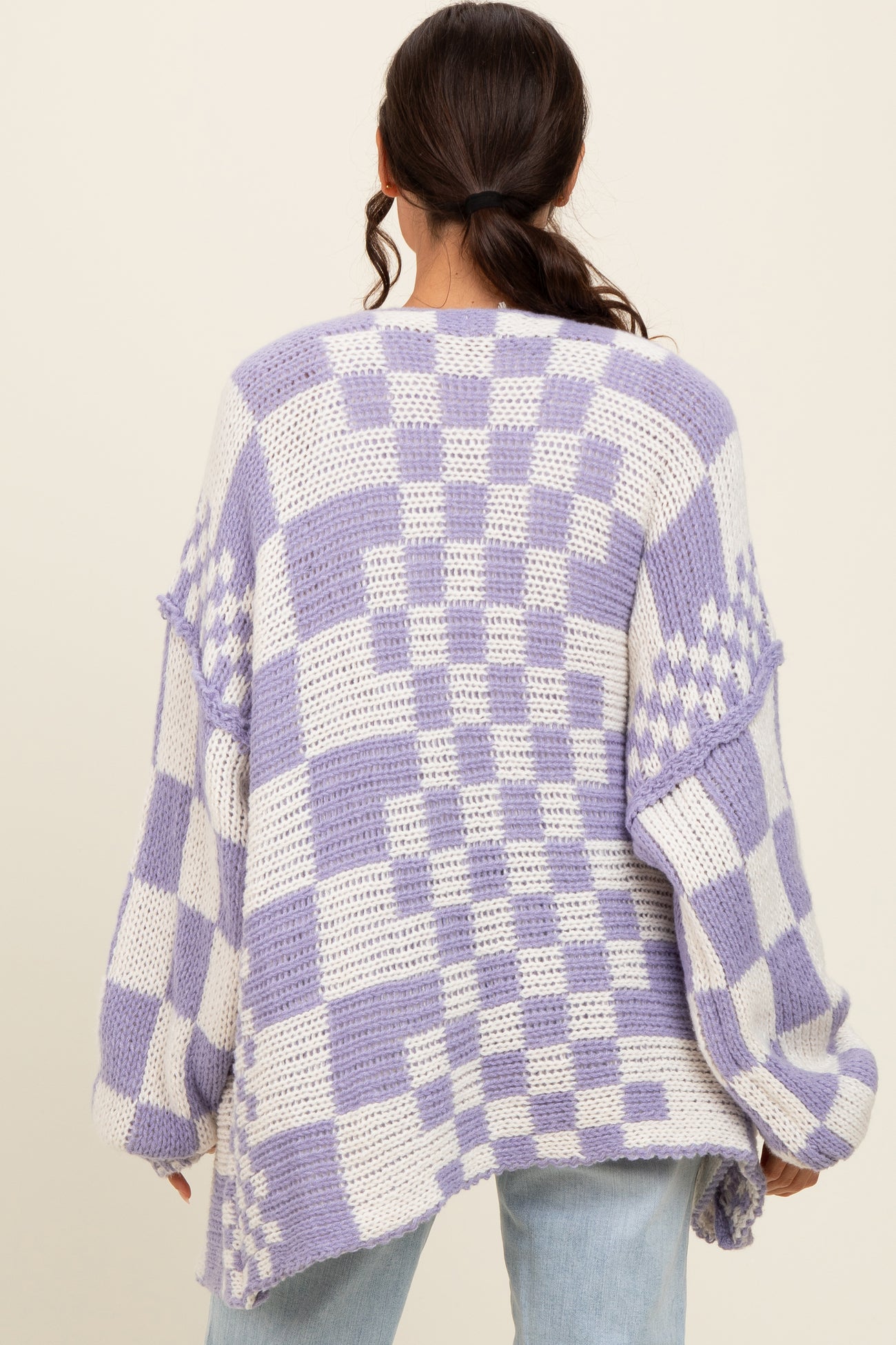 woman wearing a purple and white checkered oversized knit sweater from the back