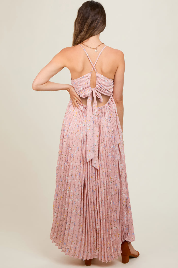 woman wearing a pink floral maternity maxi dress with a tied back and pleated skirt