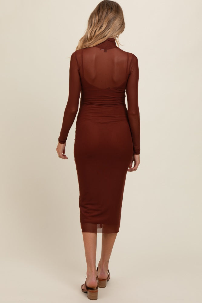 woman wearing a brown long sleeve maternity dress with a fitted silhouette and sheer back detail