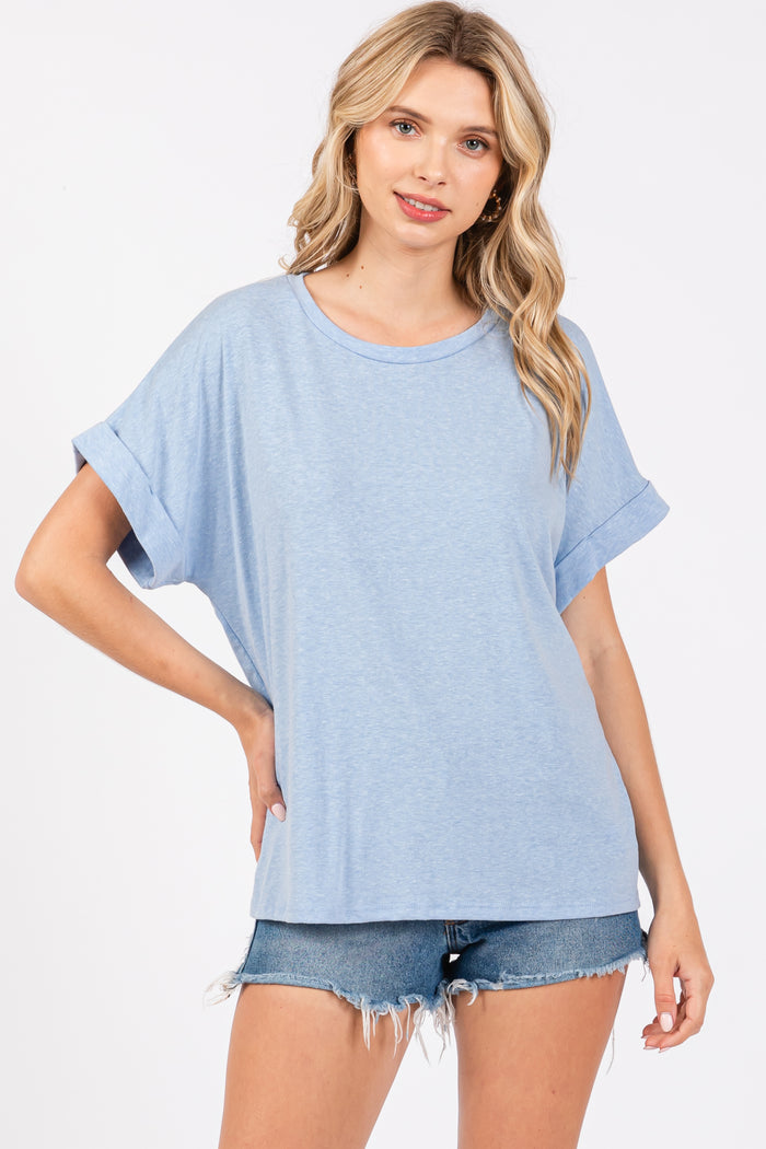 woman wearing a light blue oversized t-shirt with rolled sleeves and styled with denim shorts