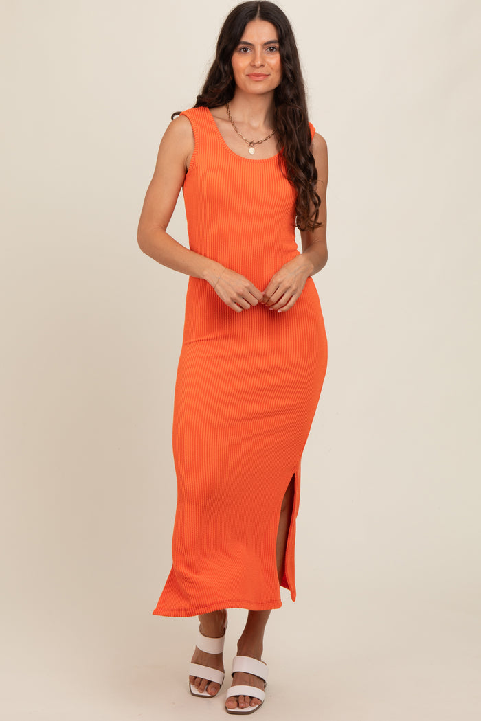 woman wearing a bright orange ribbed maxi dress with side slits and scoop neckline