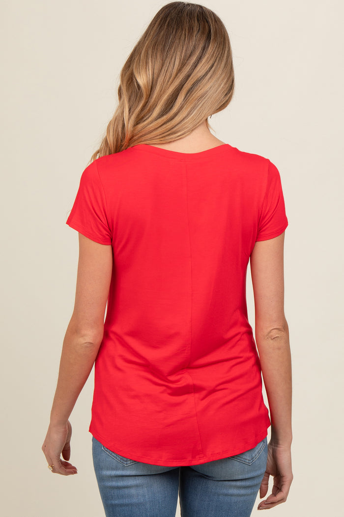 woman wearing a red short sleeve maternity top, seen from the back, paired with blue jeans