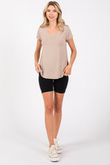 woman wearing a taupe v-neck t-shirt and black bike shorts with white sneakers