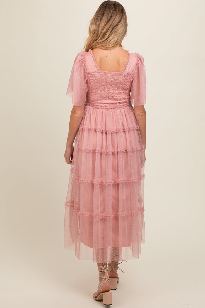 woman wearing a pink maternity dress with tiered tulle layers and short puff sleeves, viewed from the back