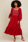 woman wearing a red smocked maxi dress with puff sleeves and a flounced hemline