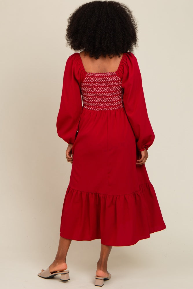 woman wearing a red maxi dress with a smocked bodice and puff sleeves, featuring a ruffled hem