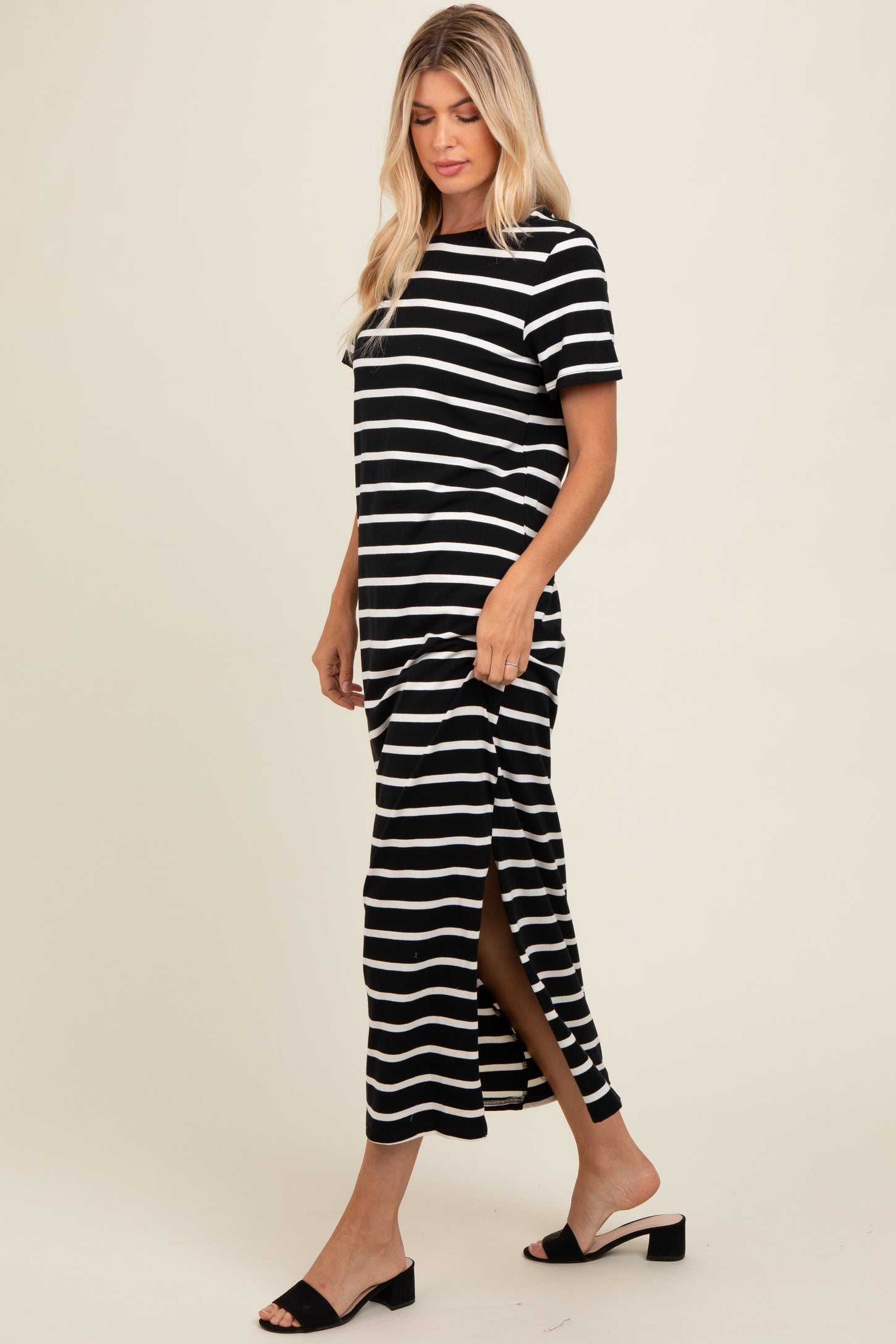 woman wearing a black and white striped maxi dress with side slits and short sleeves