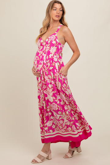 woman wearing a pink floral maternity dress with pockets and a flowing skirt, showcasing her baby bump