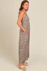 woman wearing a long floral print maxi dress with pockets and strappy shoulders
