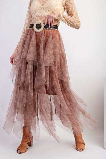 woman wearing a flowy brown layered tulle skirt with a wide belt and tan heeled sandals
