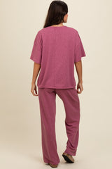 woman wearing a relaxed fit purple lounge set with a short sleeve top and wide-leg pants