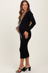 woman wearing a black ribbed maternity dress with white piping and displaying her baby bump