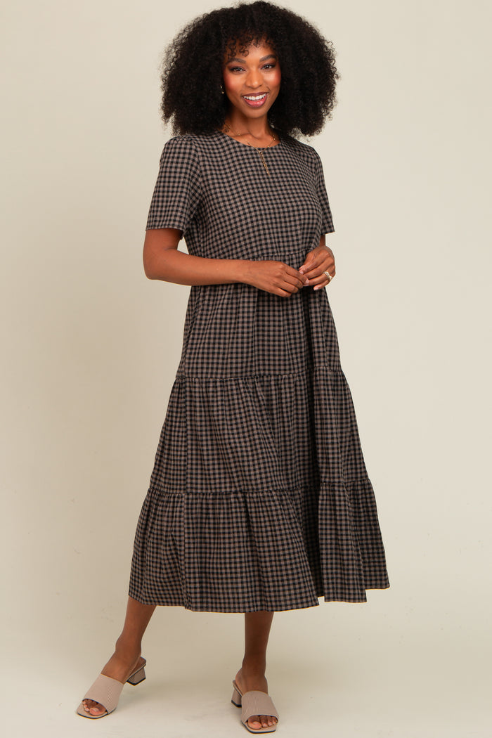 woman wearing a brown checkered tiered maxi dress with short sleeves and posing casually