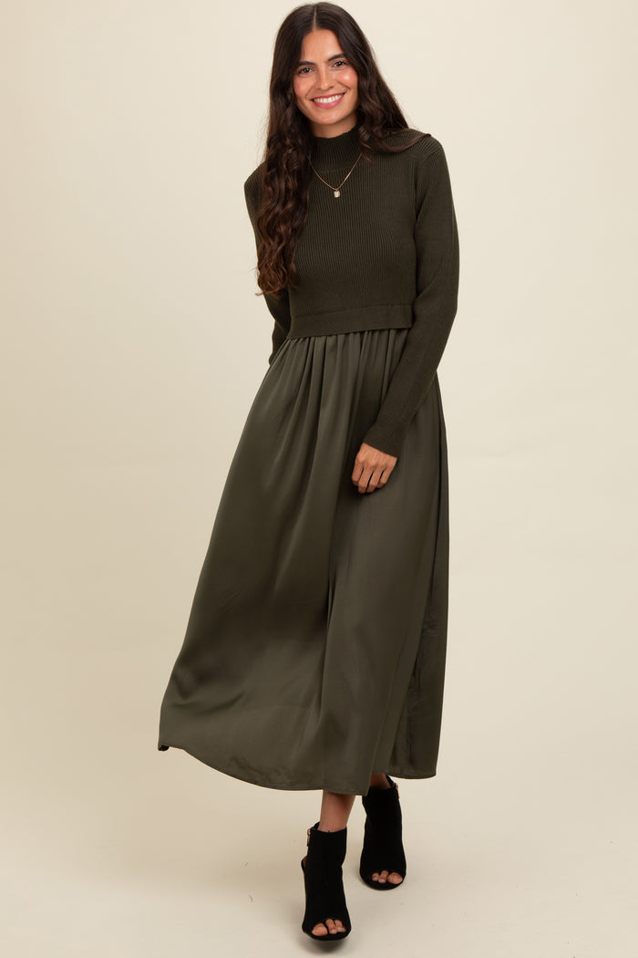 woman wearing a dark olive green long sleeve cropped sweater with a matching maxi skirt and black heeled ankle boots