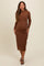woman wearing a brown long sleeve maternity dress with a fitted silhouette and visible baby bump