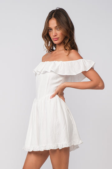 woman wearing a white off-the-shoulder mini dress with ruffle details and a flared skirt