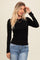 woman wearing a black long sleeve fitted top with gathered side detail and blue jeans