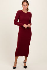 woman wearing a burgundy long sleeve ribbed midi dress and black heeled shoes