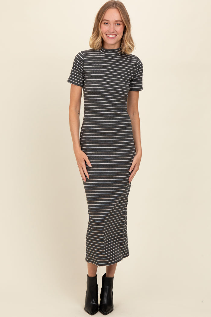 woman wearing a gray and white striped short sleeve midi dress styled with black ankle boots