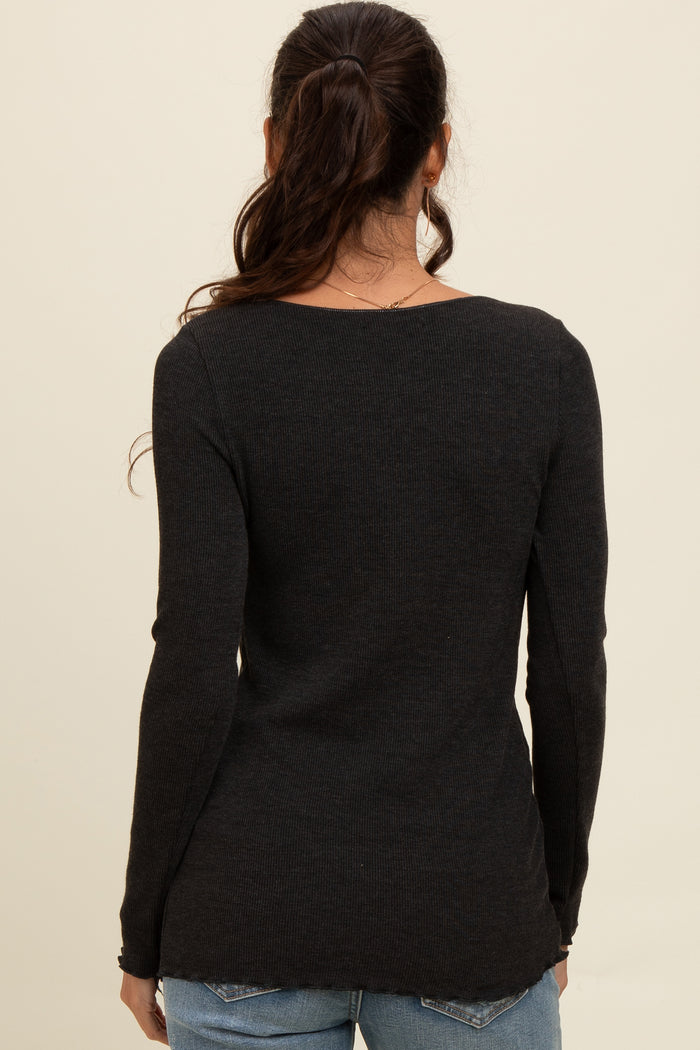woman wearing a black long sleeve ribbed sweater, viewed from the back, paired with blue jeans