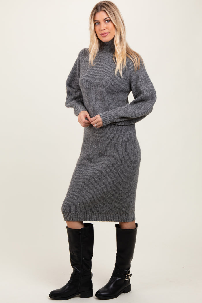 woman wearing a gray ribbed knit long sleeve sweater dress and black knee-high boots